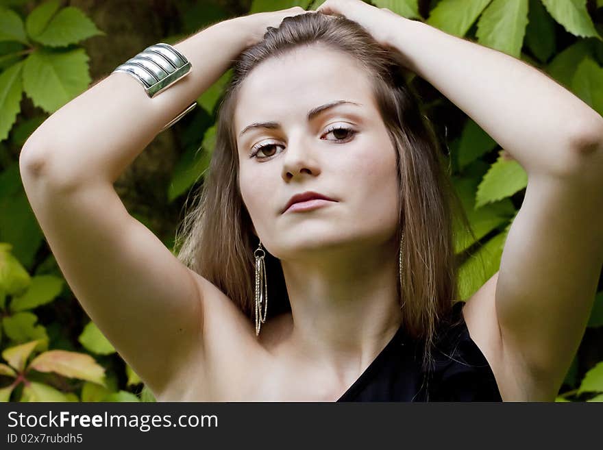 View of a beautiful girl on a black dress on a park. View of a beautiful girl on a black dress on a park.