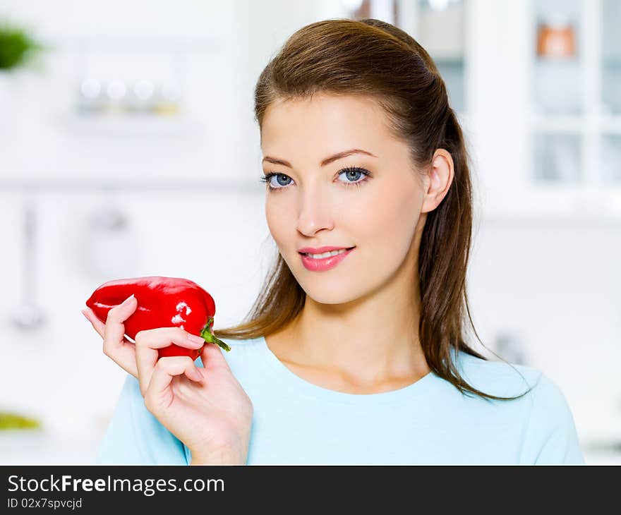 Beautiful woman with red pepper on kitchen. Beautiful woman with red pepper on kitchen