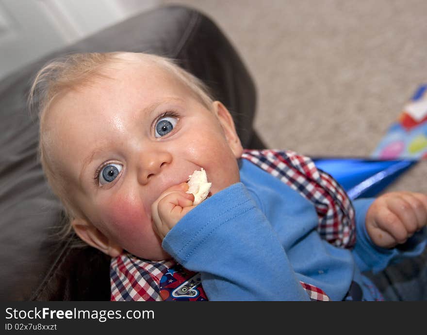 Happy baby boy on first birthday eating a sandwich. Happy baby boy on first birthday eating a sandwich