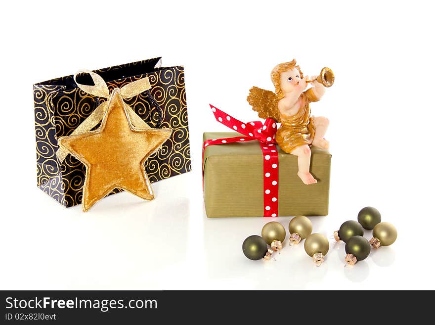 Christmas-balls in front of a present with an Angel playing the trumpet isolated on white background. Christmas-balls in front of a present with an Angel playing the trumpet isolated on white background