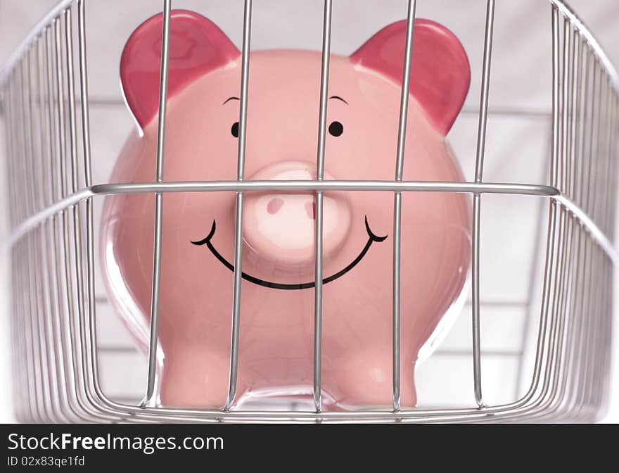 Piggybank behind cage