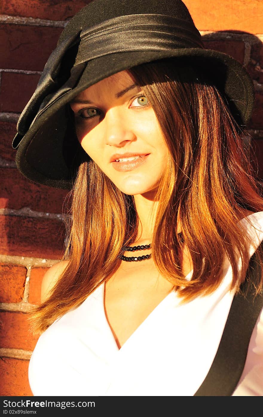 Portrait of a beautiful young woman in a black hat. Portrait of a beautiful young woman in a black hat