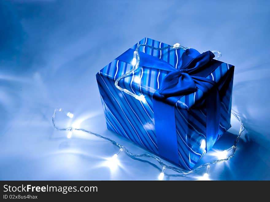 Blue gift box with ribbon and garland . Studio shot. Blue gift box with ribbon and garland . Studio shot