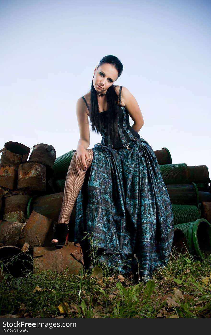 Woman wearing designer gothic dress in an industrial setting. Woman wearing designer gothic dress in an industrial setting