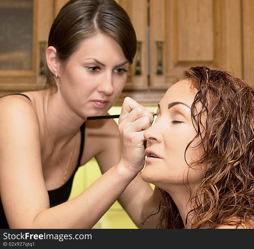 Make up artist applying eyeshadow on female model. Make up artist applying eyeshadow on female model