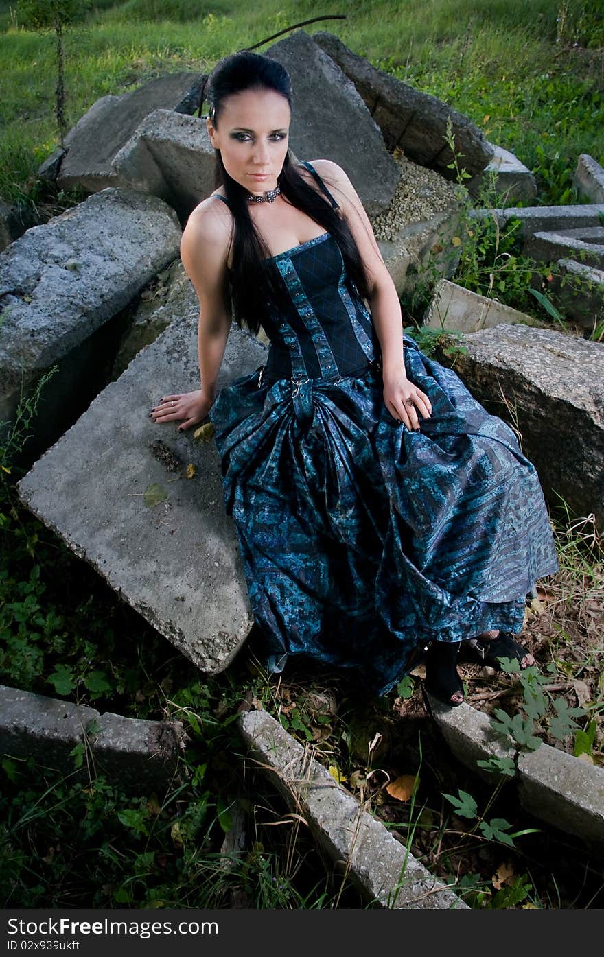 Woman wearing designer gothic dress in an industrial setting. Woman wearing designer gothic dress in an industrial setting