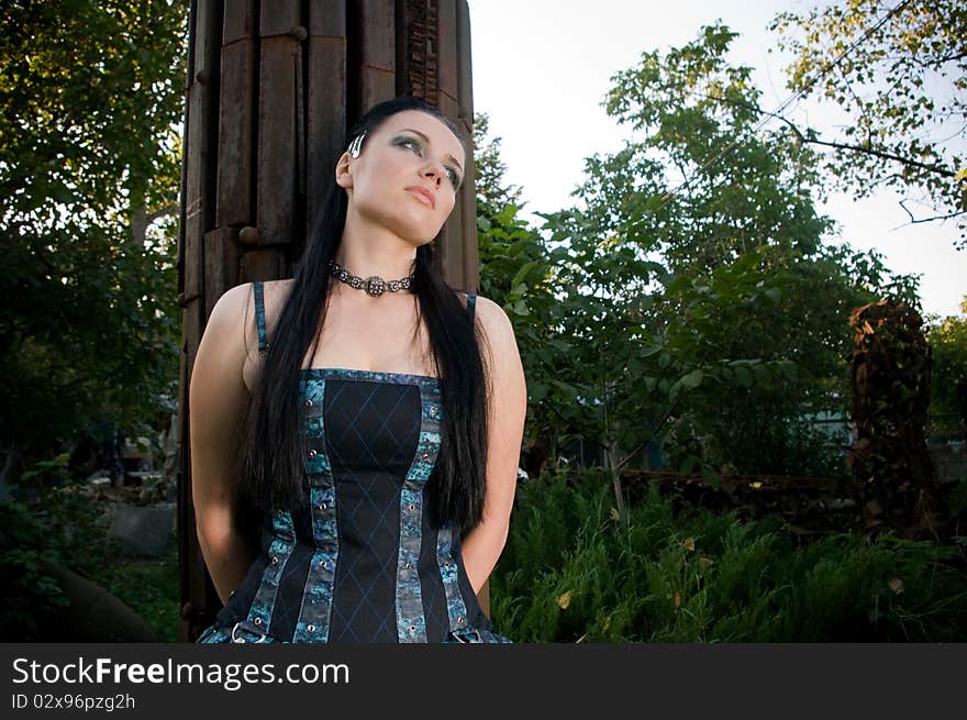 Woman wearing designer gothic dress in an industrial setting. Woman wearing designer gothic dress in an industrial setting