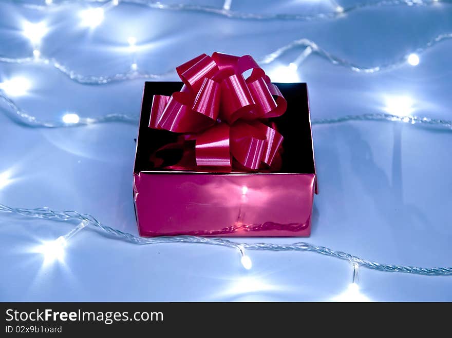 Red gift box with bow and white garland