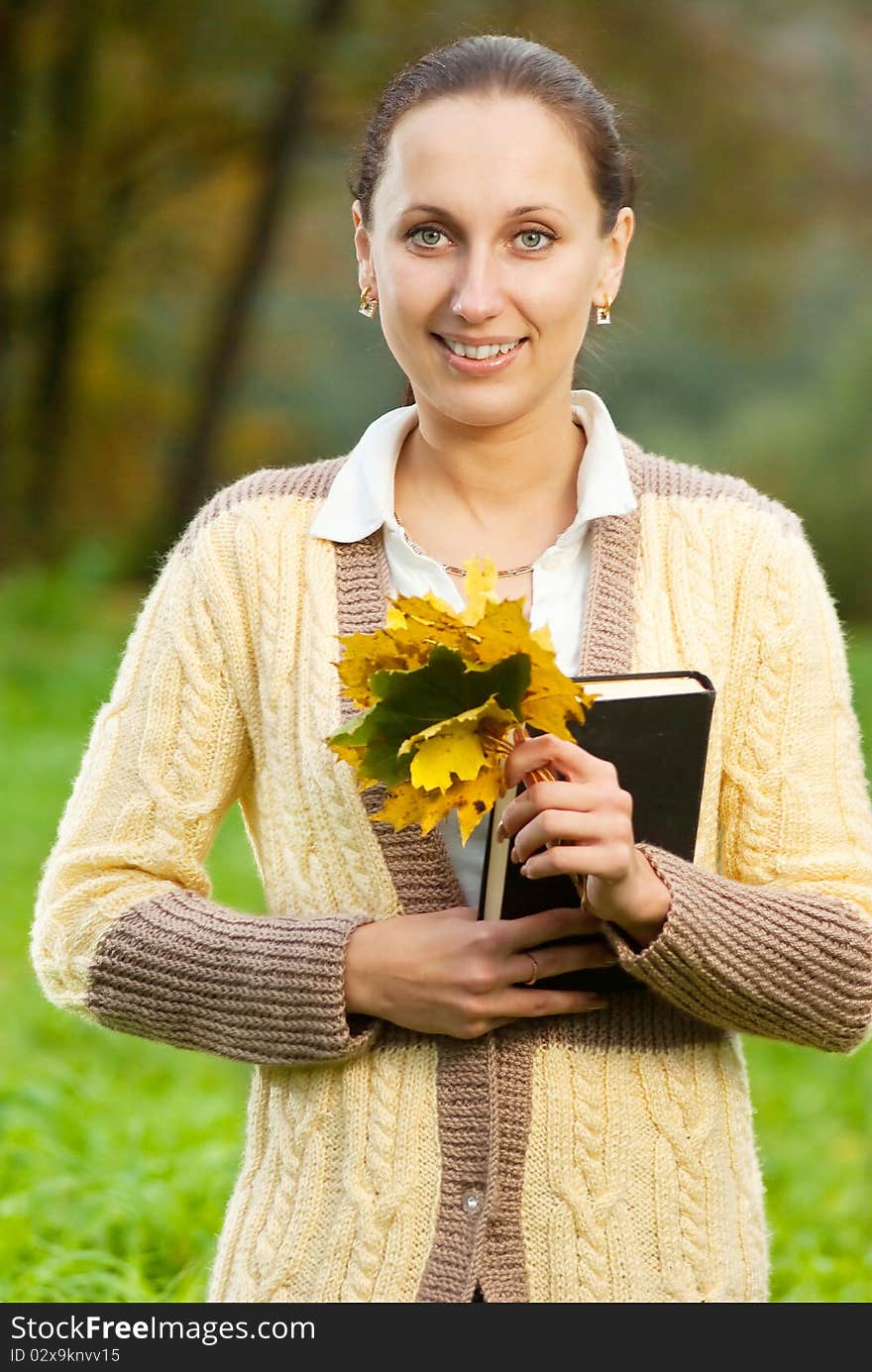 Pretty woman in the autumn park with leaves in hand