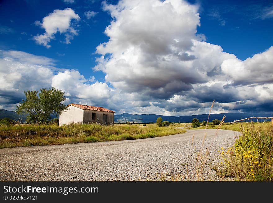 Idilic landscape with little house and road