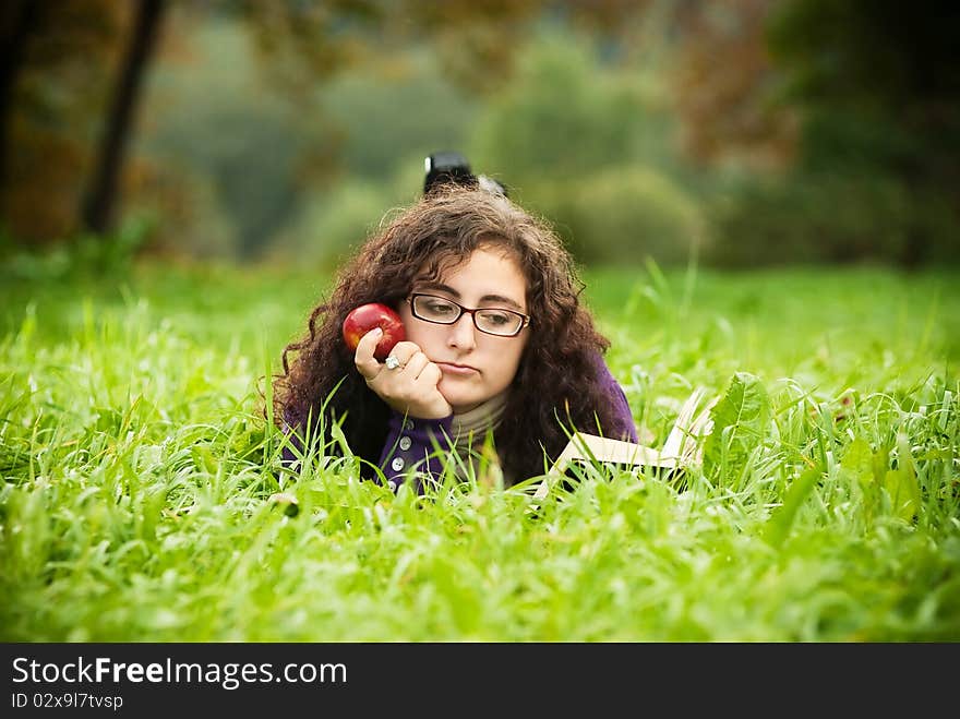 Woman lays on a grass and reads the book. Woman lays on a grass and reads the book