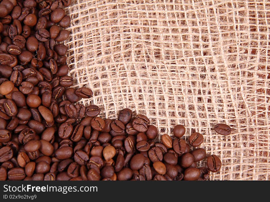 Coffee beans on burlap material background