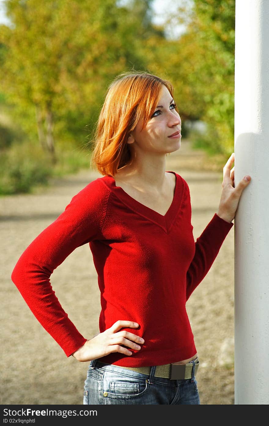 Young redhead girl outdoor, hand on pole