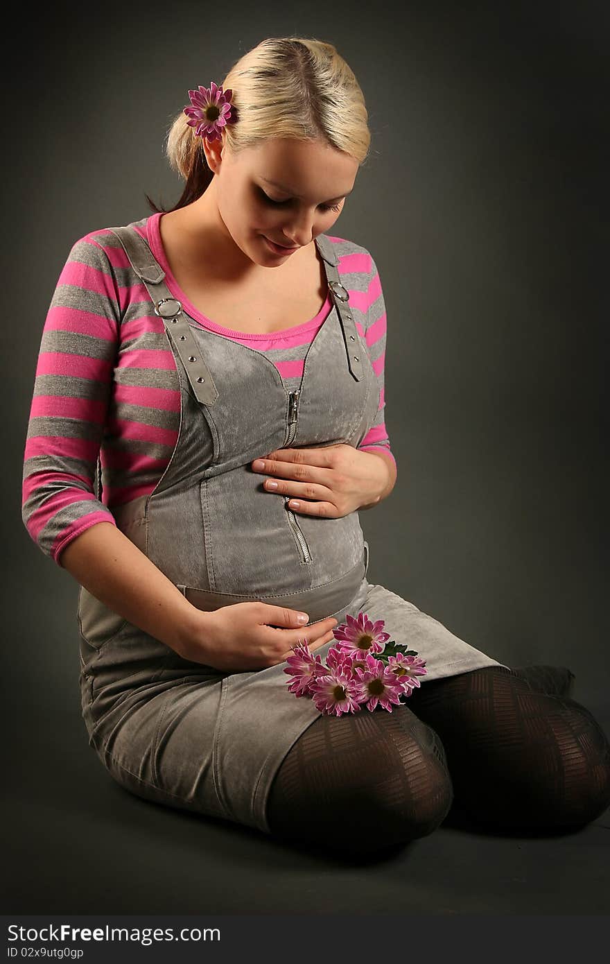 Pregnant young woman on dark background. Pregnant young woman on dark background