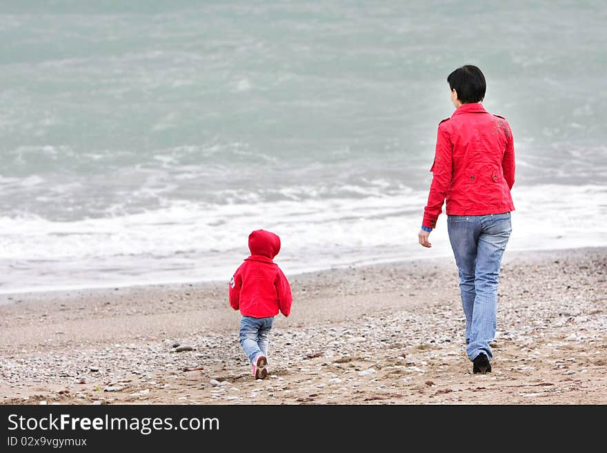 Mother and child walking on beach. Mother and child walking on beach