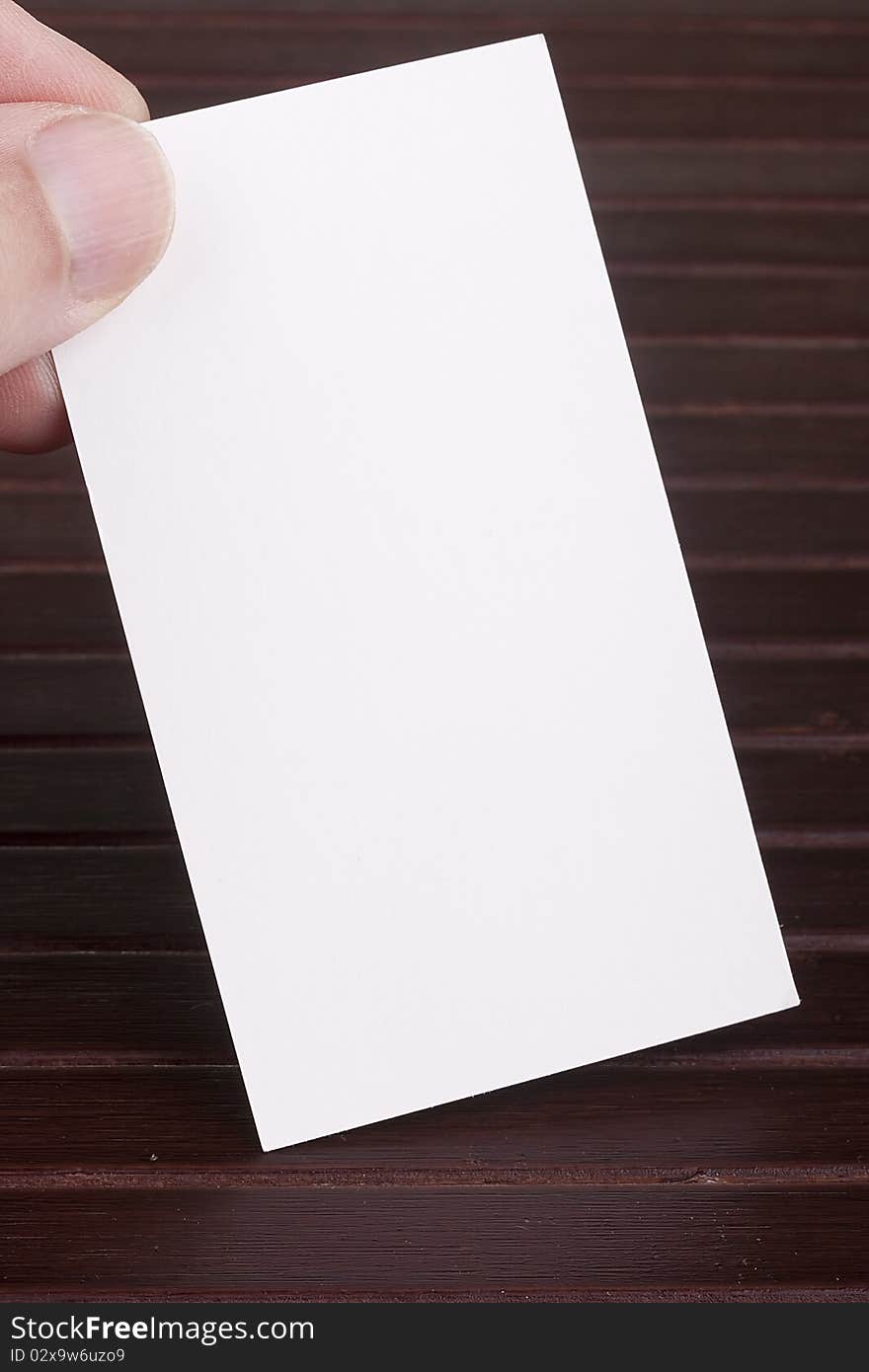 White sheet of construction paper in the form of a business card in a man's hand.