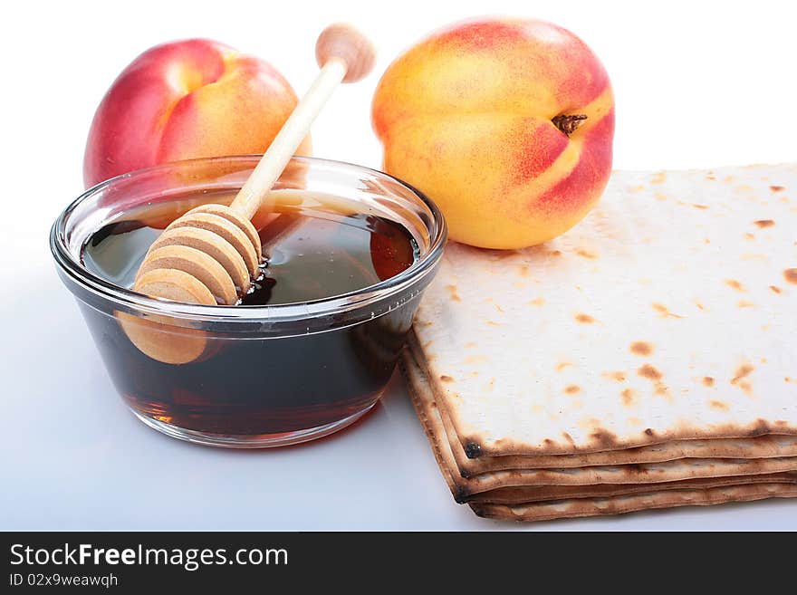 Honey in a glass vase with a special spoon, matzah and nectarine.