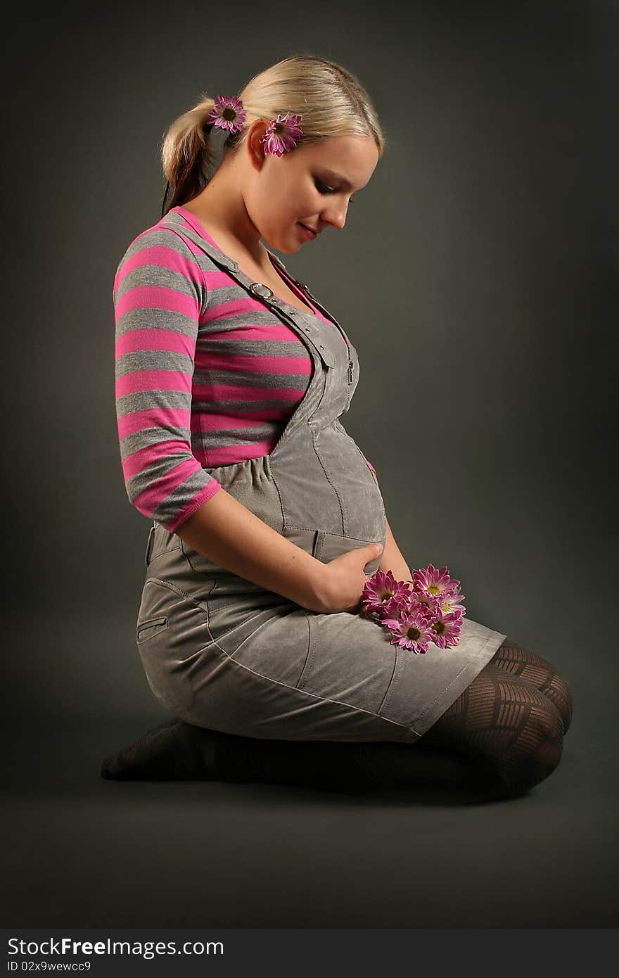 Pregnant young woman on dark background. Pregnant young woman on dark background