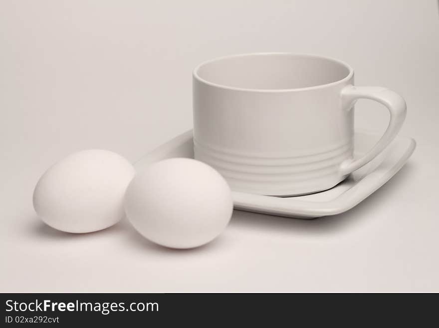 White Cup And Two Eggs