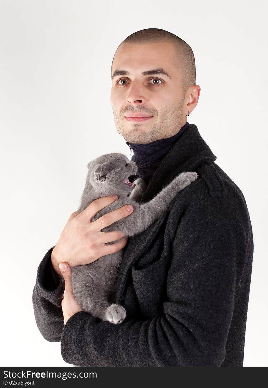 Young man with a small kitten on a white background. Young man with a small kitten on a white background