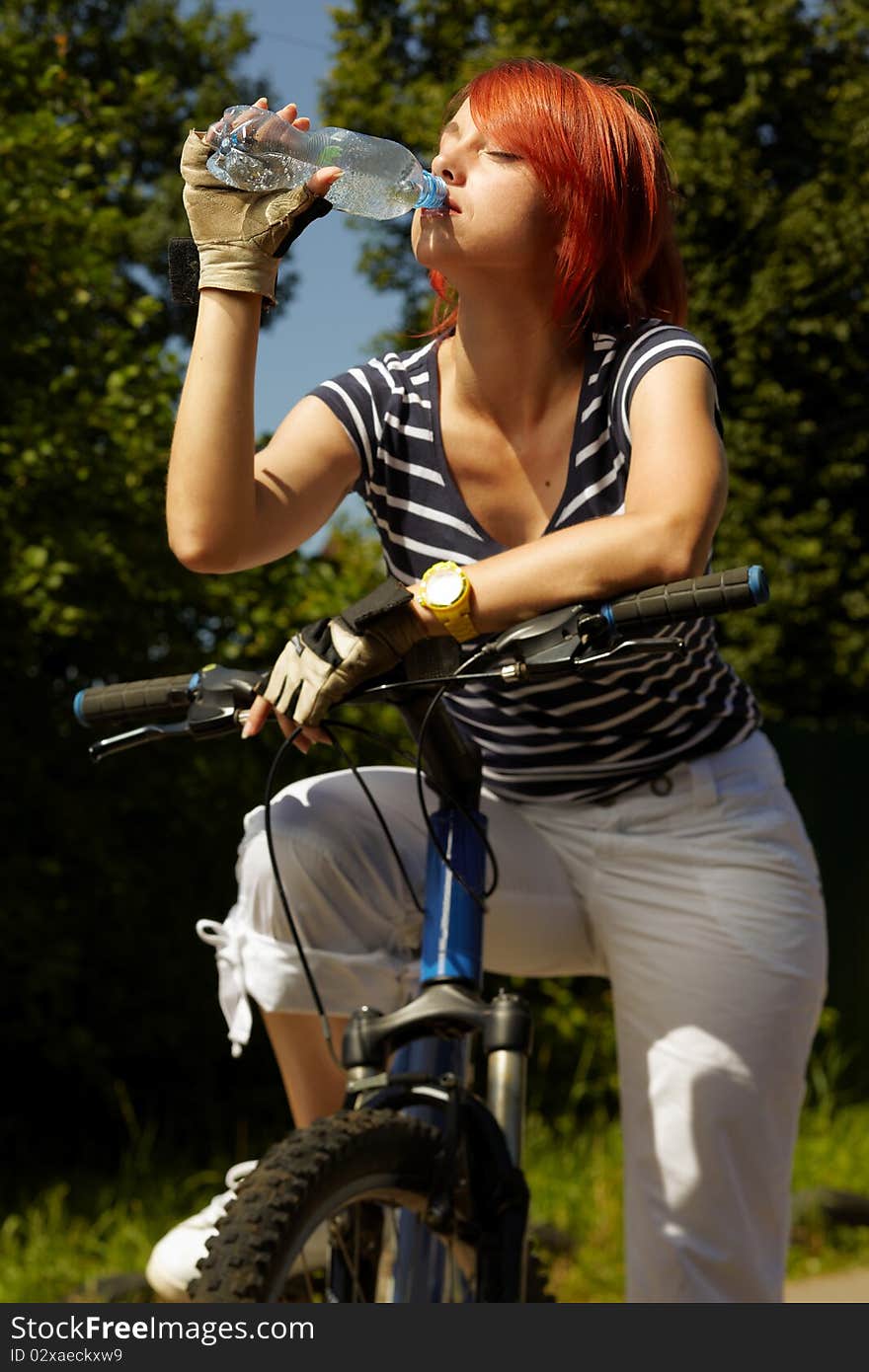 Young adult smiling biker woman on mounting bike