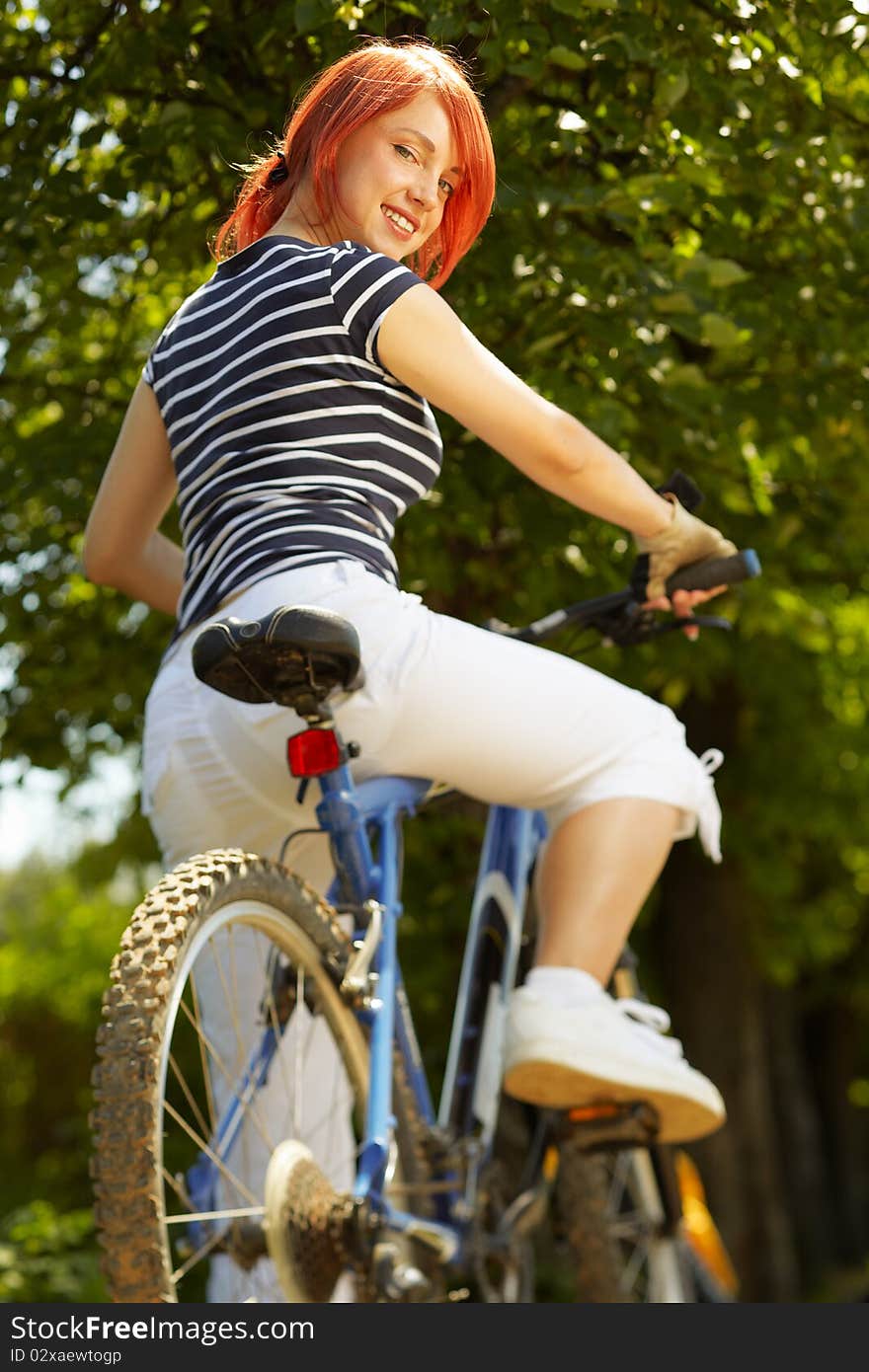 Young adult smiling biker woman on mounting bike