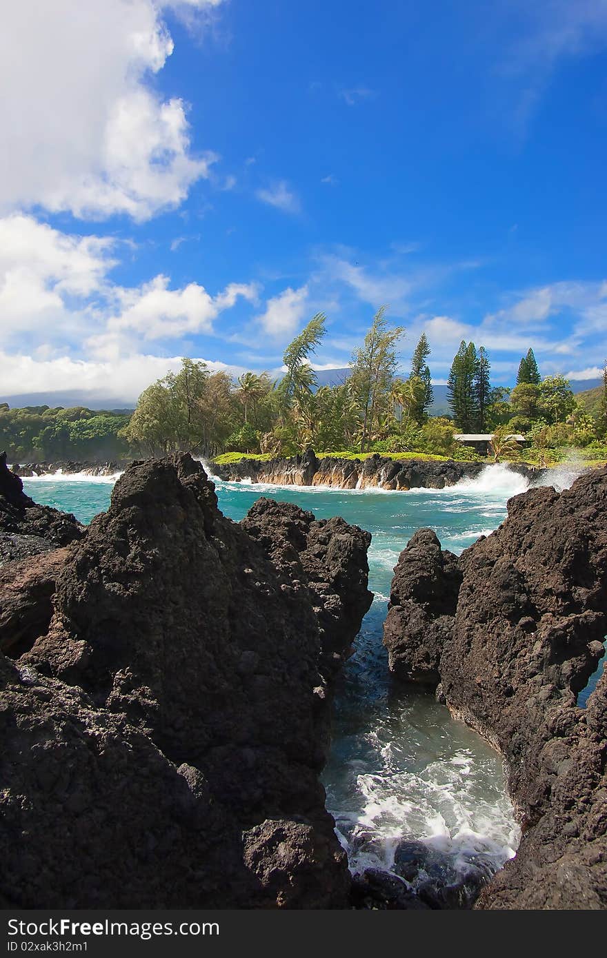 Rocky coastline with waves breaking on rocks. Tropical Island in Caribbean Sea.