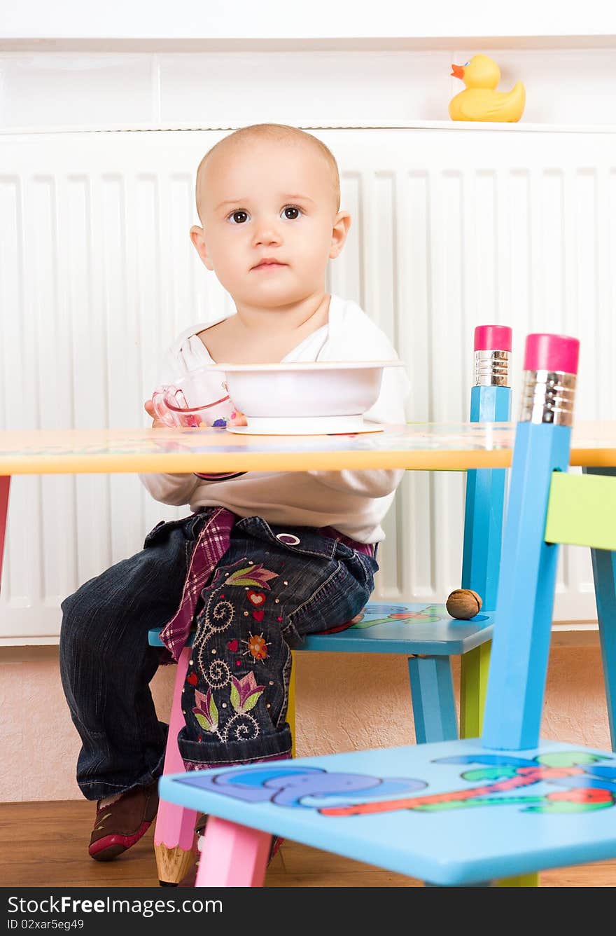 Little girl at the table in the kitchen. Little girl at the table in the kitchen.