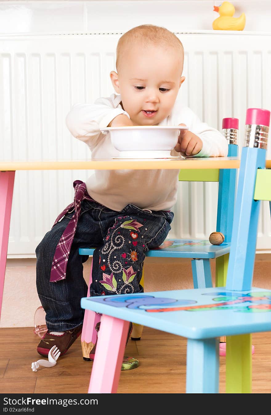 Little girl at the table in the kitchen. Little girl at the table in the kitchen.