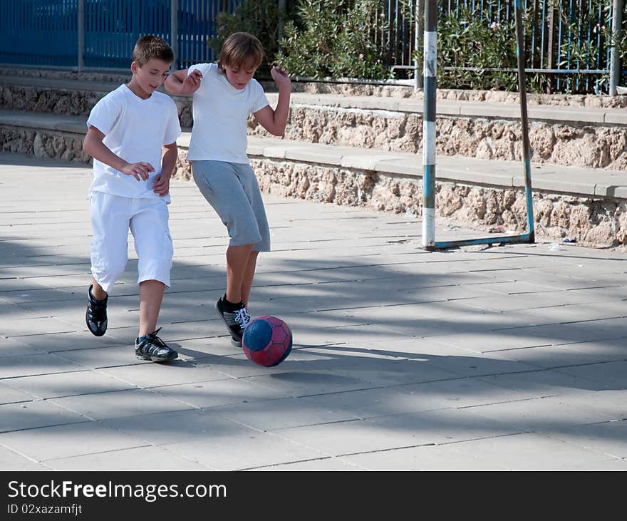 Teenage boys playing soccer at sunny day . Teenage boys playing soccer at sunny day .