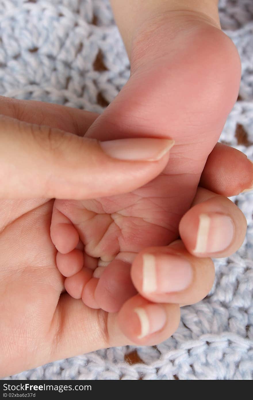 Mother holding foot of a newborn baby. Focus on wrinkles on Foot. Mother holding foot of a newborn baby. Focus on wrinkles on Foot.