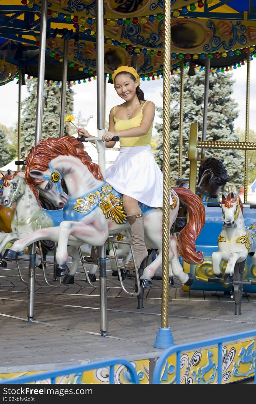 Happy girl riding a horse in park