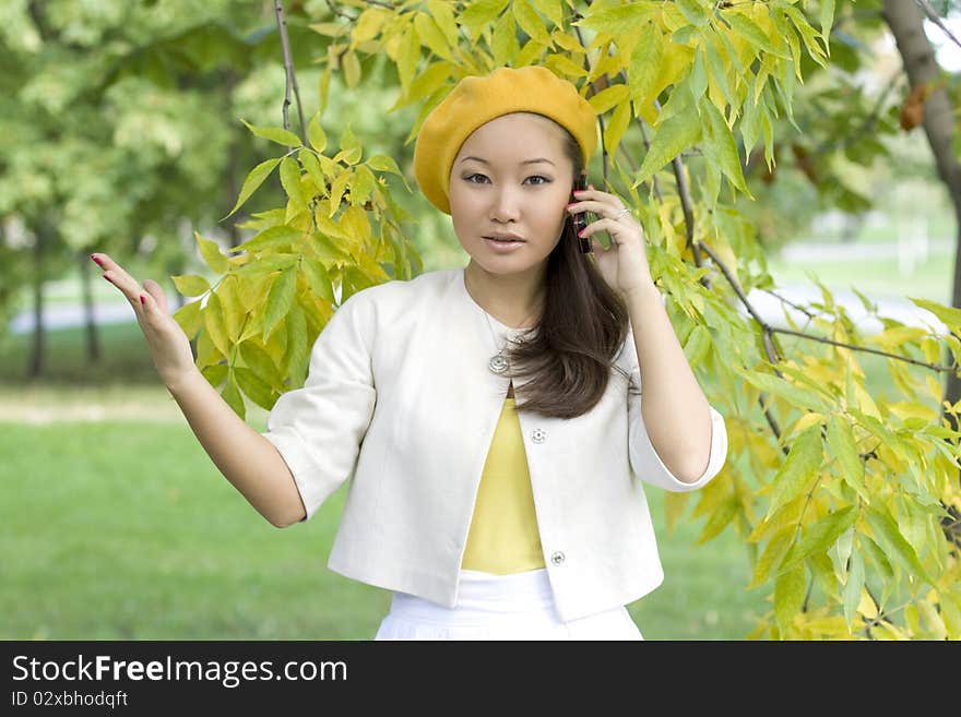 Girl talking by phone in autumn park