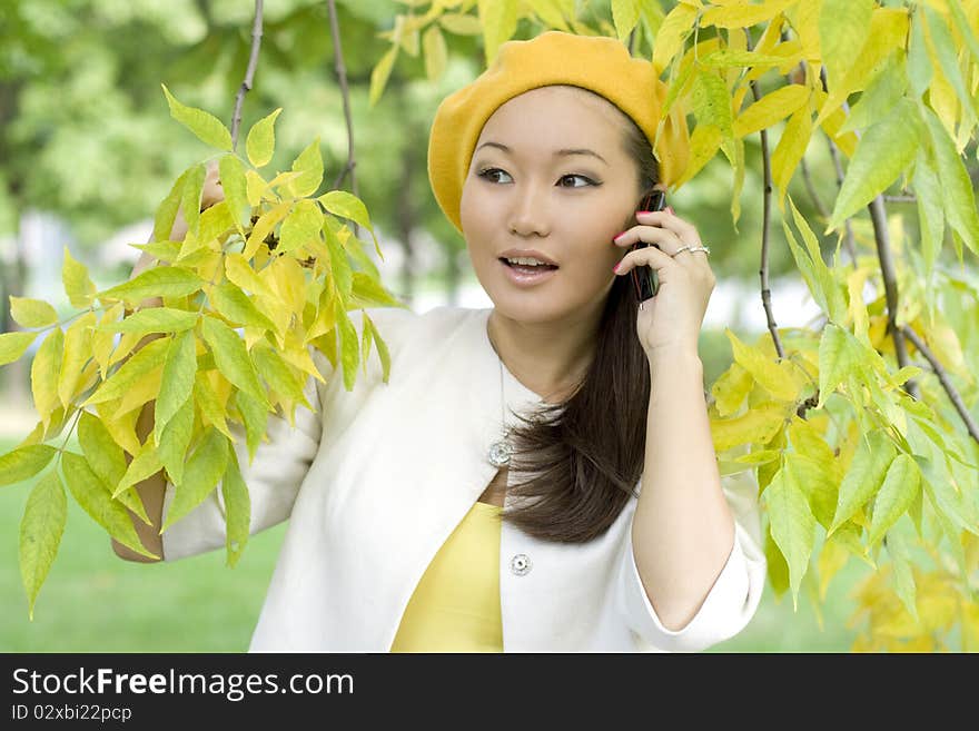 Girl talking by phone in autumn park