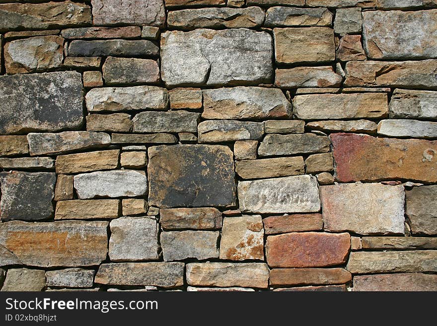 Various sizes and colors of stones in a wall. Various sizes and colors of stones in a wall