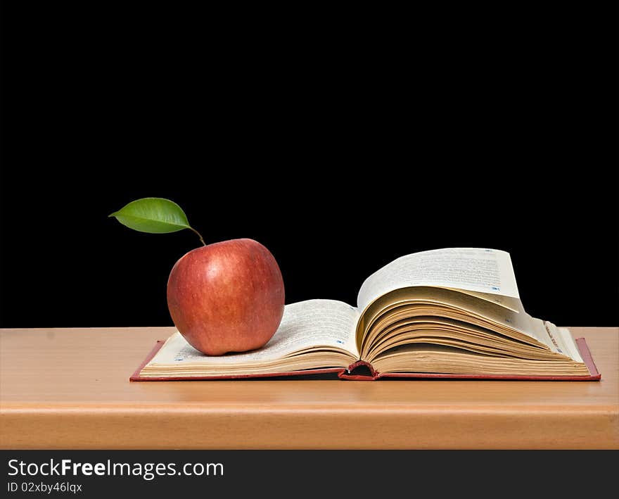 Red apple and book on desk