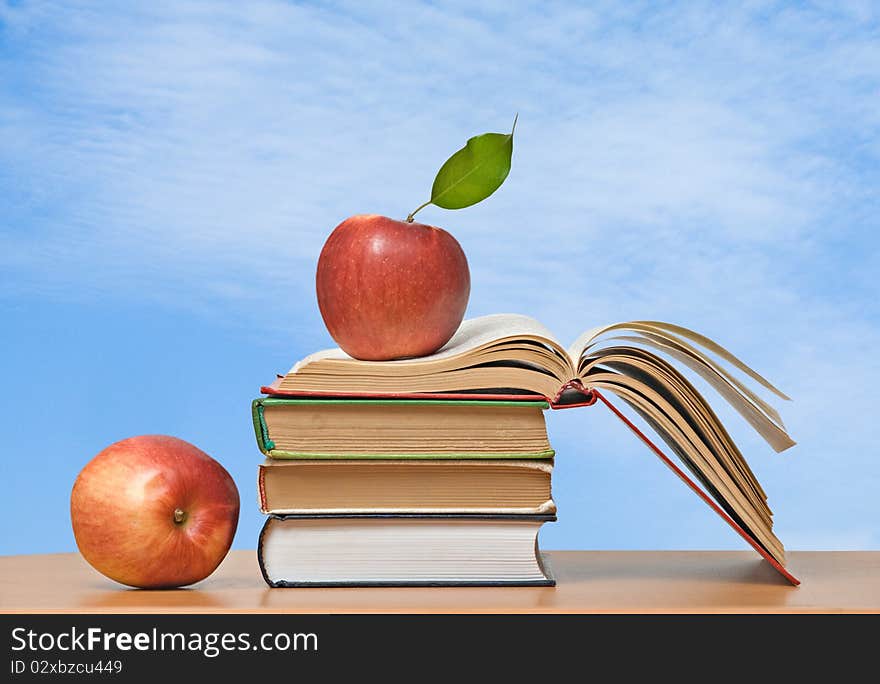 Red apples and books on desk