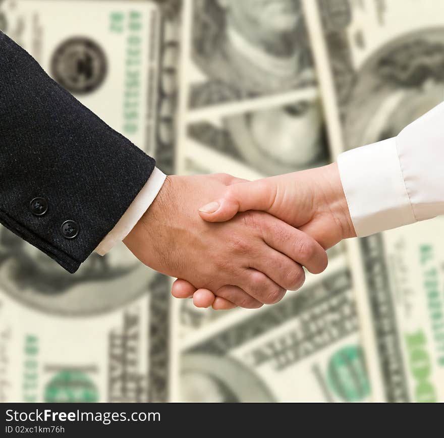 Handshaking man and woman on money background