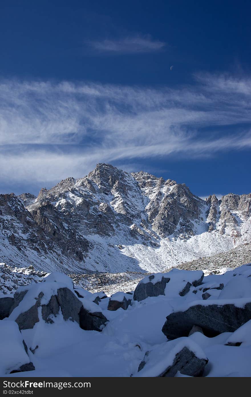 Photo of Pogranichny peak in Sayan Mountains. Moon is visible. Photo of Pogranichny peak in Sayan Mountains. Moon is visible.