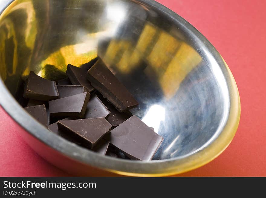 Crushed dark chocolate in a cooking bowl