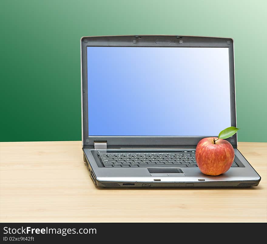 Notebook and apple on desk