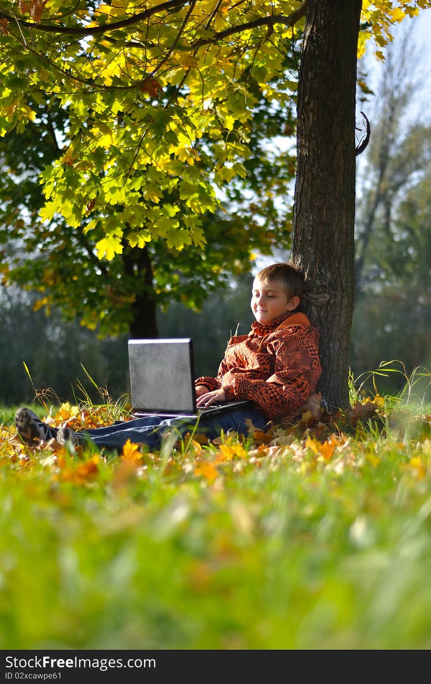 Child make fun with notebook under tree in autumn forest. Child make fun with notebook under tree in autumn forest