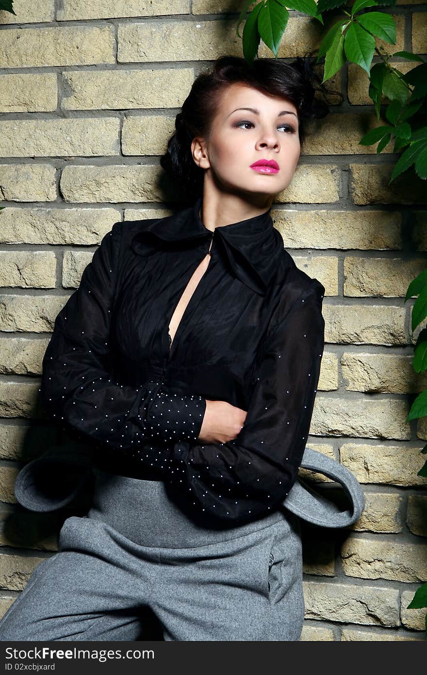 Young and attractive lady beside with brick wall, overgrown of vine leaves. Young and attractive lady beside with brick wall, overgrown of vine leaves