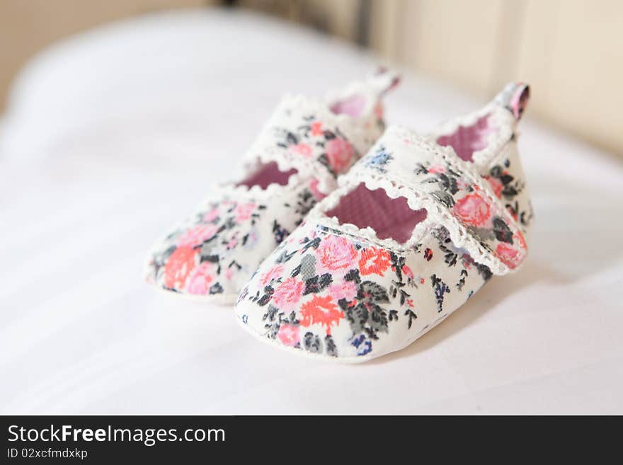 Hand made baby bootees standing on the pillow. Hand made baby bootees standing on the pillow