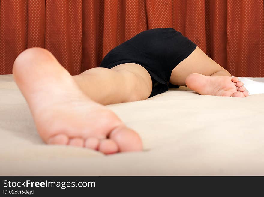 A sleeping young girl with her feet open on bed