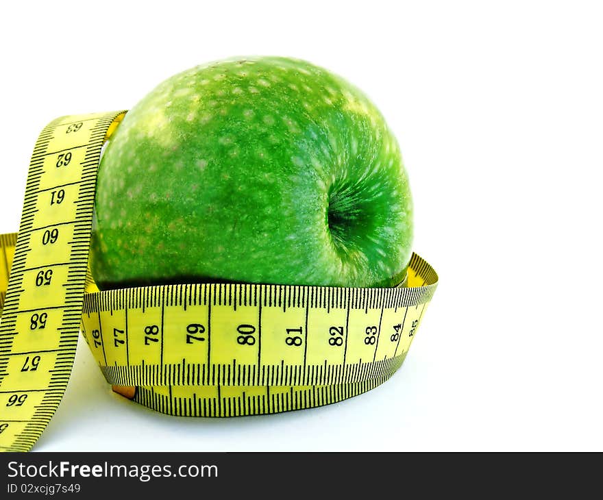 A fresh green apple with a yellow measuring tape on a white background. A fresh green apple with a yellow measuring tape on a white background