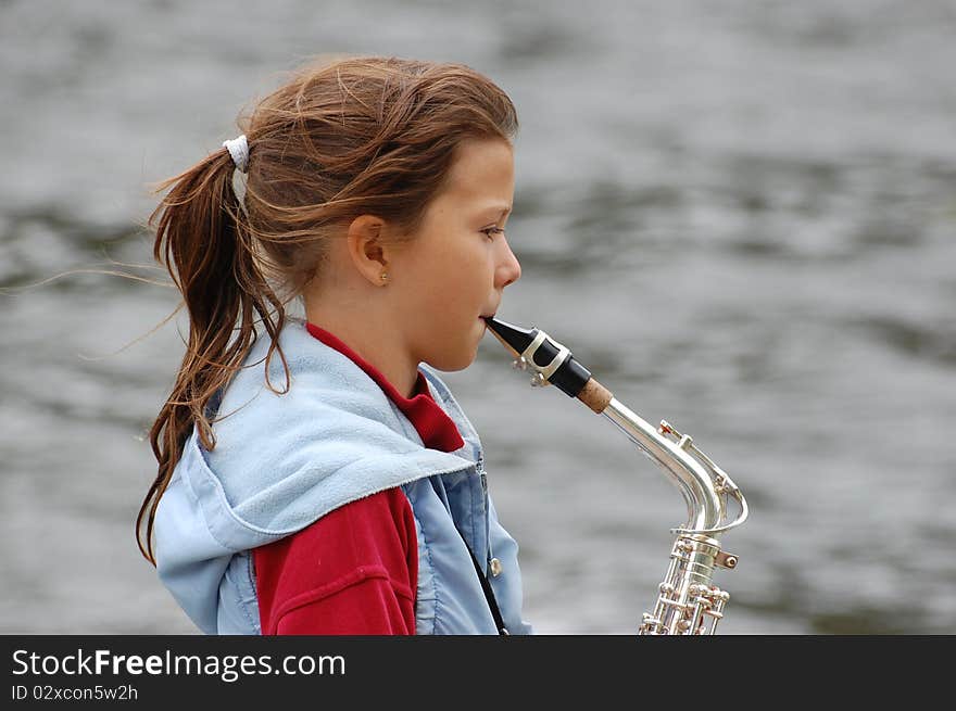 Girl with saxophone outdoor.Near Kiev,Ukraine