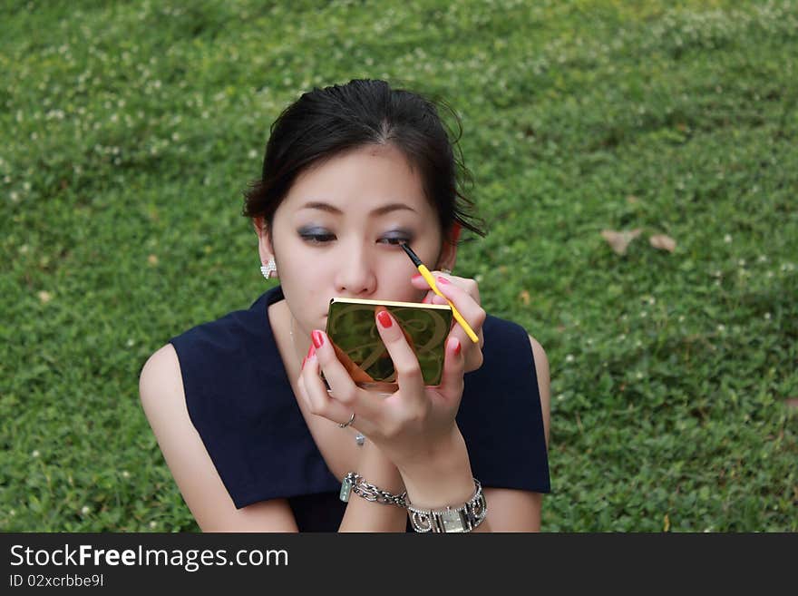 Beautiful woman applying colorful eye makeup. Beautiful woman applying colorful eye makeup