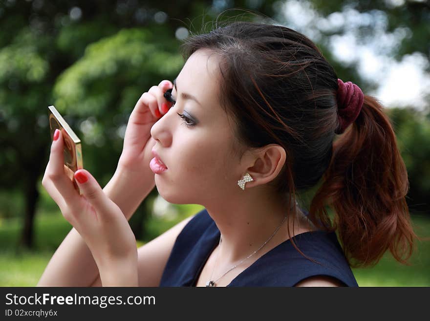 Beautiful woman applying colorful eye makeup. Beautiful woman applying colorful eye makeup