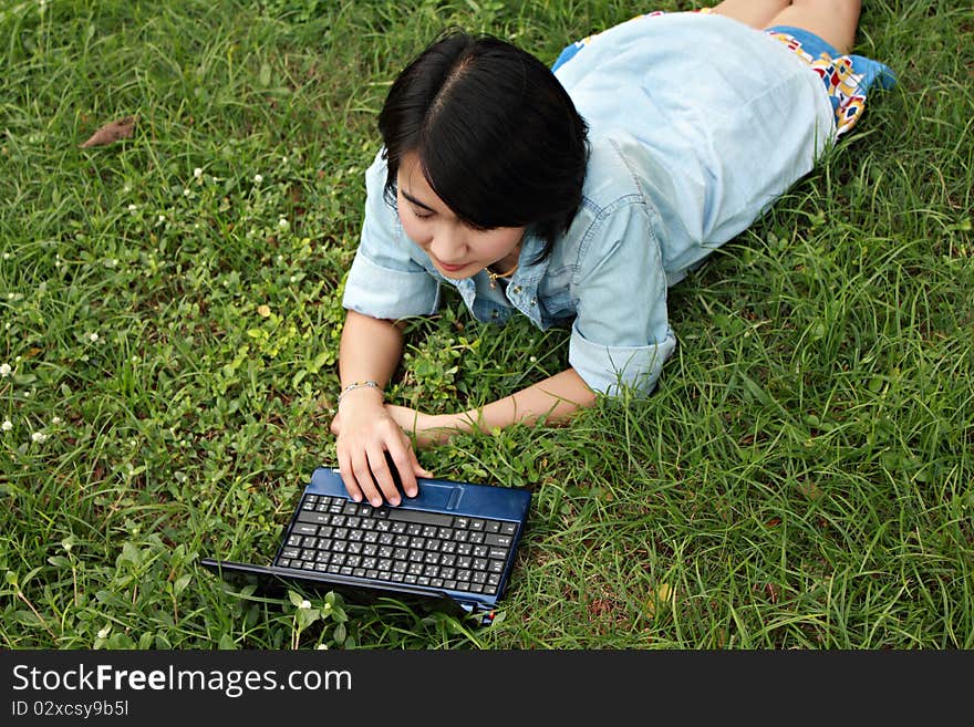 A smiling young girl with laptop outdoors